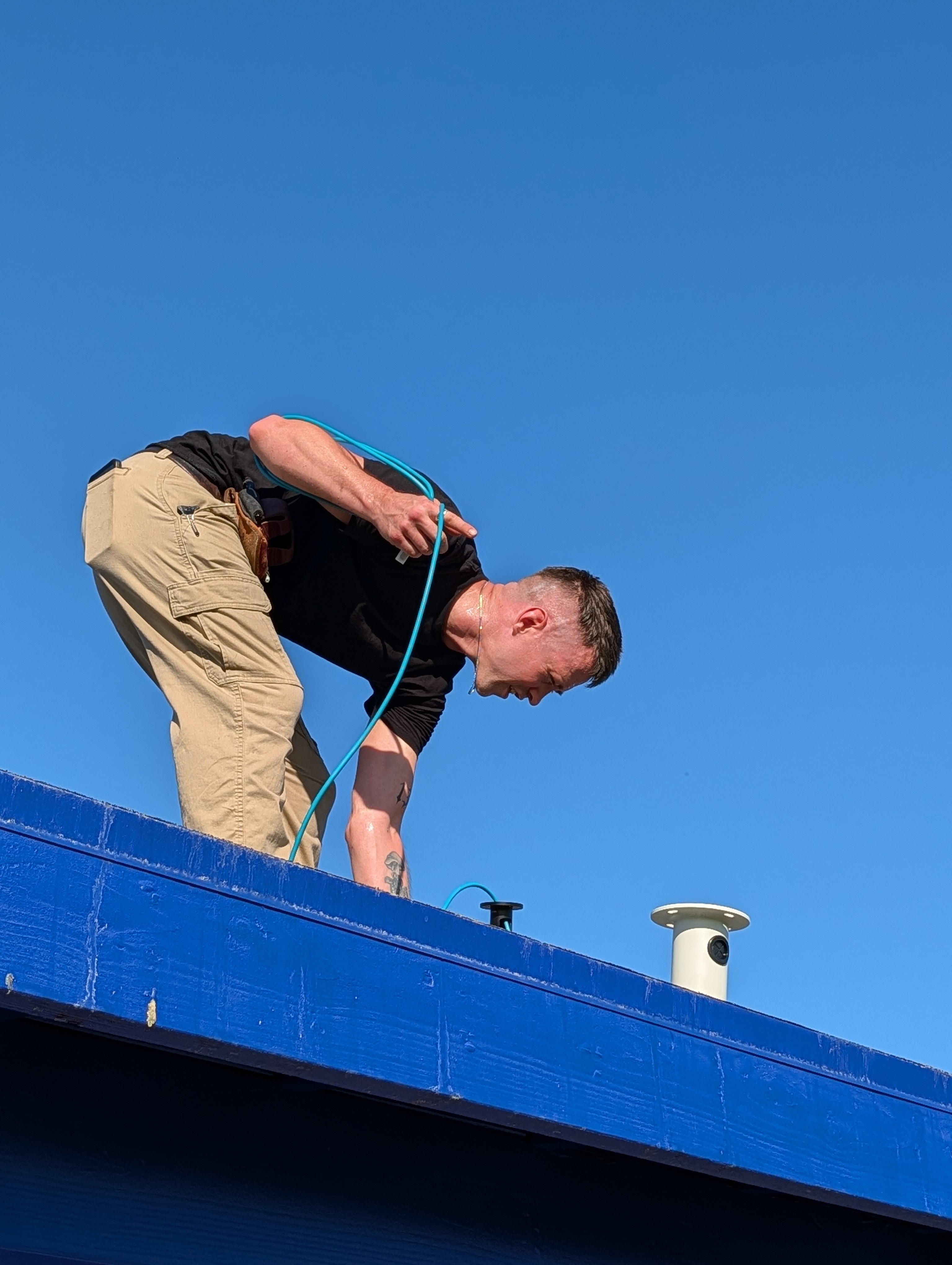 KnC technician routing cable beside a mounted field camera